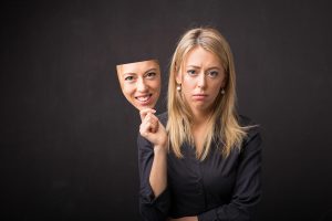 woman removing mask of limiting karma